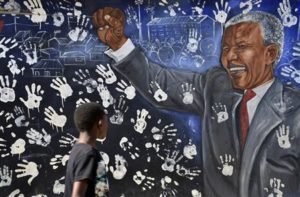 Boy walks past a mural painted outside the house former South African President Nelson Mandela once lived in, in Johannesburg's Alexandra township