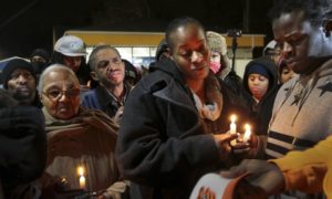 Toni Martin-Green, front center, and her husband Jerome Green, right, participate in a candlelight vigil at a Berkeley, Mo., gas station on Wednesday, Dec. 24, 2014.