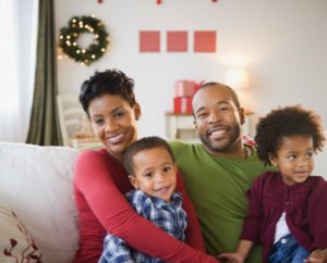 Jersey City, New Jersey, USA --- Black family relaxing on sofa together --- Image by © JGI/Jamie Grill/Blend Images/Corbis
