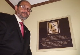 Daryl Scott, national president of the Association for the Study of African American Life and History, unveils a new plaque commemorating group’s 100 years. ((WBEZ/Natalie Moore) 