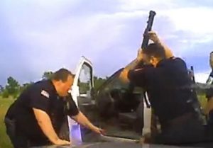 This video screen grab shows the incident in which allegations of use of excessive force were raised. Owasso Police Officer Michael Denton is the officer with the shotgun raised, police have confirmed.  (Tulsa World)