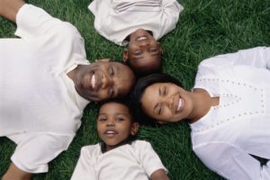Black family lying on grass