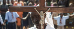 A girl carrying a cross arrives to celebrate mass at Saint Charles Lwanga church in Bangui,  car.  AFP PHOTO / FRED DUFOUR        (Photo credit should read FRED DUFOUR/AFP/Getty Images)