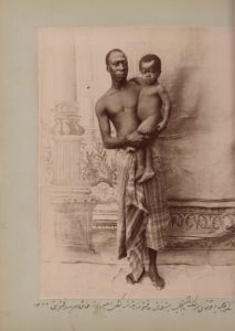  In this staged photo taken by Zell-e Soltan at his summer hunting palace near Isfahan, one of his African slaves holds his son. According to the caption, the infant (Iqbal) is the real son of the adult African slave, Haji Yaqut Khan, suggesting he wasn’t a eunuch and could father his own children. The caption says that Yaqut Khan is in his ethnic clothes (languteh), which was mainly worn by Africans outside of Iran. Photograph: Zell-e-Soltan/Modern Conflict Archive, London, UK
