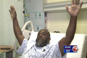 Charles Kinsey, 41, demonstrates how he had his hands in the air shortly before he was shot by police. Image courtesy of ABC 7.