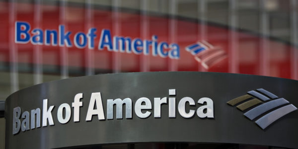 A Bank of America logo hangs above a bank branch entrance in