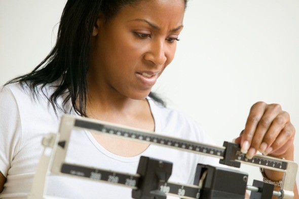 Black Woman Looking At Scale