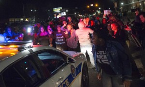 Protestors block a police vehicle from entering the City of Ferguson Police Department and Municipal Court parking lot in Ferguson Missouri