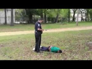 Slager stands over Scott's body, though in police report he claims he performed CPR