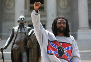 COLUMBIA, SC - JULY 18:  A man holds a black power salute during a Black Educators for Justice rally at the South Carolina state house on July 18, 2015 in Columbia, South Carolina. The White Knights of the Ku Klux Klan were scheduled to hold a rally there afterwards, and police presence was heavy to prevent altercations between the two camps.  (Photo by John Moore/Getty Images)