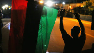 FERGUSON, MO - AUGUST 12: Demonstrators hold up a Pan-African flag to protest the killing of teenager Michael Brown on August 12, 2014 in Ferguson, Missouri. Brown was shot and killed by a police officer on Saturday in the St. Louis suburb of Ferguson. Ferguson has experienced two days of violent protests since the killing but, tonight's protest was peaceful. (Photo by Scott Olson/Getty Images)