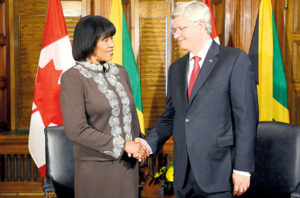 Prime Minister Stephen Harper shakes hands with Portia Simpson Miller, prime minister of Jamaica