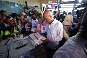 Haitian President Michel Martelly receives his ballot to vote at a polling station in the Lycee National de Petion Ville in Port-au-Prince on October 25, 2015. Haiti is holding presidential, legislative and municipal elections. (Photo credit should read HECTOR RETAMAL/AFP/Getty Images) AFP/Getty Images