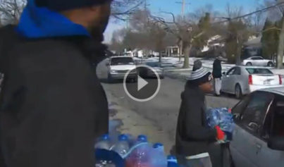 men handing out bottle water flint water crisis