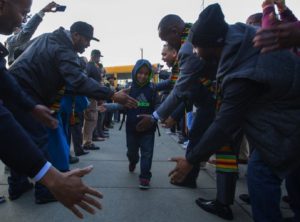 Anas Mohamed, 8, a third grader at South Shore PK-8 School in Seattle, gets high-fives as he enters his school Monday morning. The school hosts more than 250 black men Monday morning as they greet students as they walk into school. South Shore PK-8 School is hosting a day-long program Monday for National African-American Parent Involvement Day that includes greeting students with high-fives before school and speakers who will discuss how to increase the academic achievements of black male students.