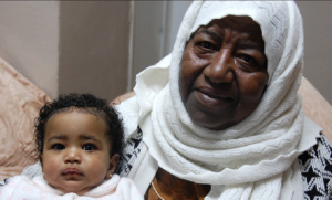 Zohra al-Qadi, member of African community in Jerusalem, holding one of her grandchildren (BBC)