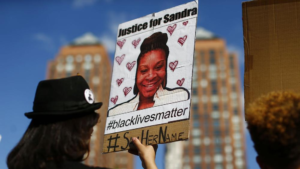 A woman holds a poster bearing the portrait of Sandra Bland. (Kena Betancur / AFP-Getty Images)