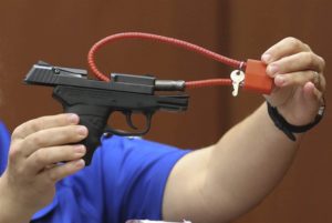 A crime scene technician shows the gun used by George Zimmerman to shoot Trayvon Martin during Zimmerman's trial in 2013. Photo by Gary W. Green / Pool via EPA