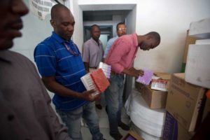 Workers count supplies that they received from health ministry, at the General Hospital in Port-au-Prince