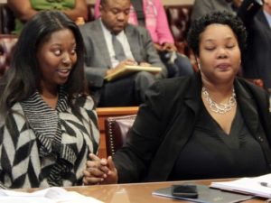 Raegan Brooks (left), one of Sam DuBose's 13 children, holds the hand of her attorney, Anita Washington, as Judge Ralph "Ted" Winkler announces how the $4.8 million dollar settlement will be distributed. Photo by: Patrick Reddy/Cincinnati.com