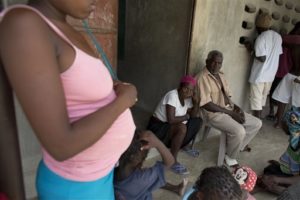 Haitians recently deported from neighboring Dominican Republic sit outside a school building where residents have allowed them to stay in the village of Fonbaya, Haiti, (AP Photo/Rebecca Blackwell)