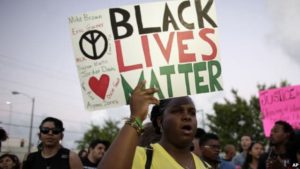 Desiree Griffiths holds up a sign saying "Black Lives Matter", with the names of Michael Brown and Eric Garner, two black men recently killed by police, during a protest , in Miami, Florida, Dec. 5, 2014. Photo by The Associated Press.