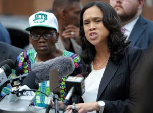Baltimore State's Attorney Marilyn Mosby, right, holds a press conference near the site where Freddie Gray was arrested after her office dropped the remaining charges against three Baltimore police officers awaiting trial in Gray's death. Gray's stepfather, Richard Shipley, is pictured left. Image by Steve Rurak/AP