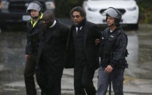 Pastor McBride, left, and Cornel West, right, arrested by officers in Ferguson, Mo during protests over the shooting of Michael Brown.
