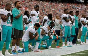 Miami Dolphins Aaron Foster (29) wide receiver Kenny Stills (10) and free safety Michael Thomas (31) take a knee during the National Anthem before the game as the New England Patriots host the Miami Dolphins at Gillette Stadium on Sunday, September 18, 2016. Photo by Al Diaz/Miami Herald