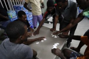 PHOTO Haitian migrants play dominoes at the Padre Chava migrant shelter, in Tijuana, Mexico. AP: GREGORY BULL