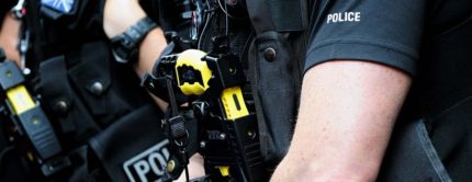 Police officers carrying Tasers
