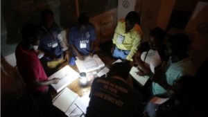 Electoral workers are seen during the counting at a polling station as Haiti holds a long-delayed presidential election after a devastating hurricane and more than a year of political instability, in Port-au-Prince, Haiti, November 20, 2016.Image copyrightREUTERS Image caption Electoral workers were counting votes by the light of a lantern in the capital, Port-au-Prince