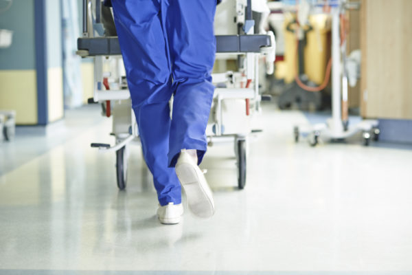 Legs of medic running with gurney along hospital corridorLegs of medic running with gurney along hospital corridor