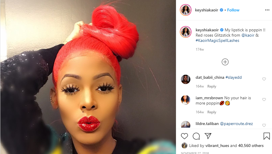 Keyshia Ka’oir wearing red glittered lipstick from her cosmetics line @keys...