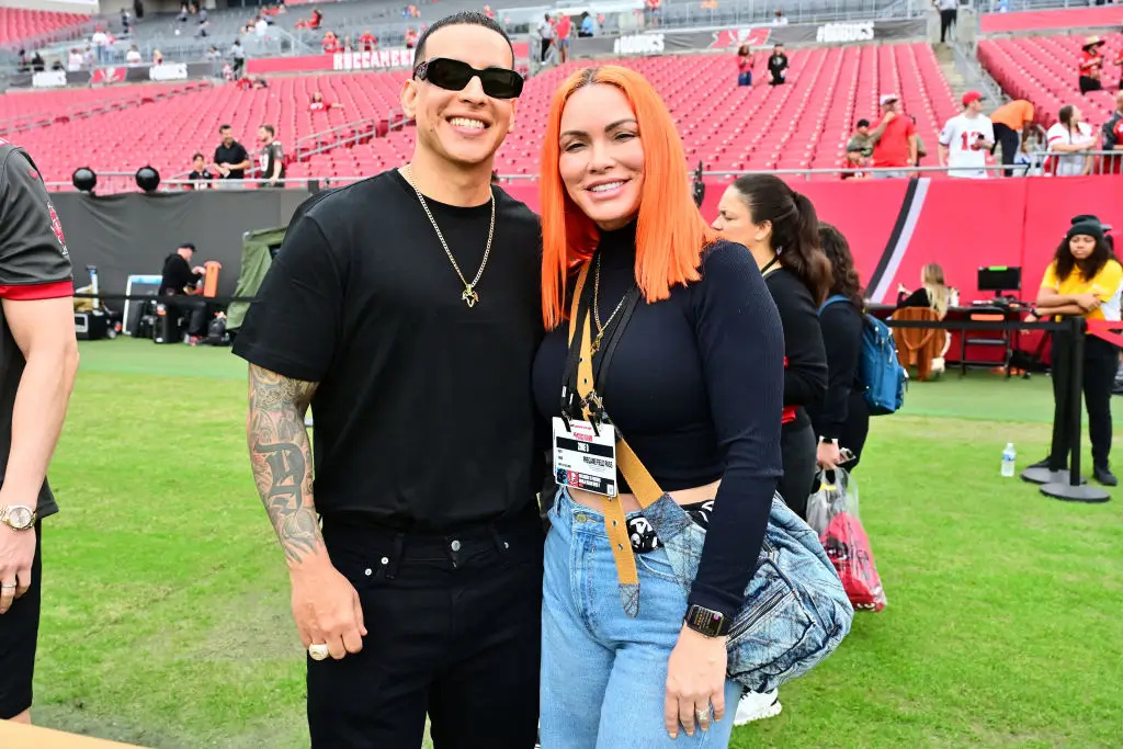 TAMPA, FLORIDA - JANUARY 01: Recording artist Daddy Yankee and his wife Mireddys González pose for a photo on the field before the game between the Tampa Bay Buccaneers and the Carolina Panthers at Raymond James Stadium on January 01, 2023 in Tampa, Florida. (Photo by Julio Aguilar/Getty Images)
