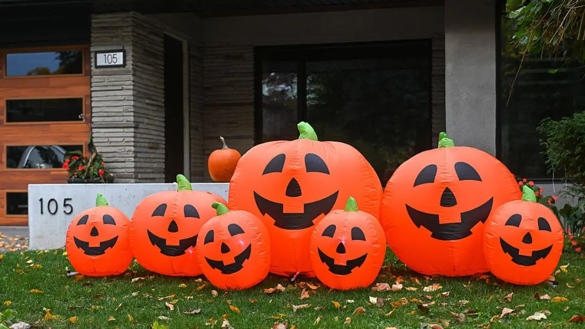 TORONTO, ONTARIO, CANADA - 2025/10/25: A collection of seven smiling orange inflatable jack-o'-lantern decorations of varying sizes are displayed on the front lawn of a modern suburban home two days before Halloween. (Photo by Julia Cherkasova/Informa Plus Photo Agency/LightRocket via Getty Images)